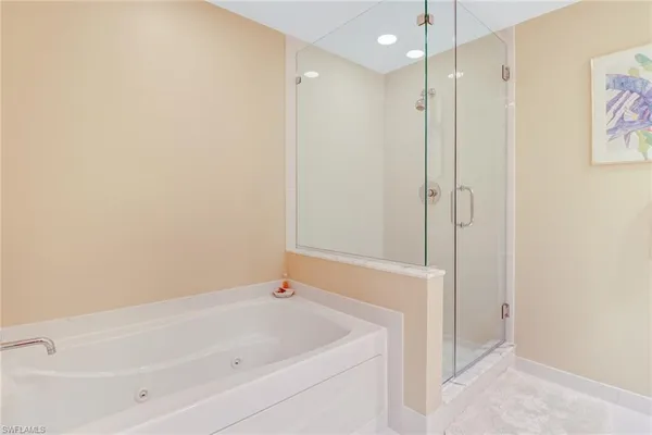 a white bath tub sitting next to a shower