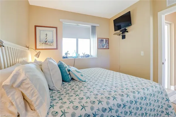 a bedroom with a bed and a flat screen tv