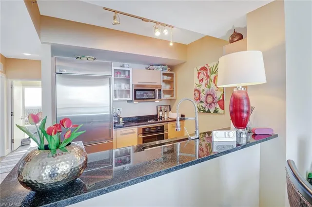 a kitchen with granite countertop lots of clutter and stainless steel appliances