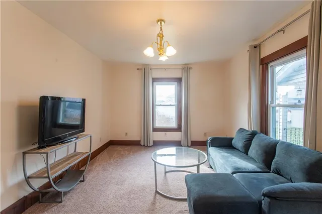 a living room with furniture a flat screen tv and a window