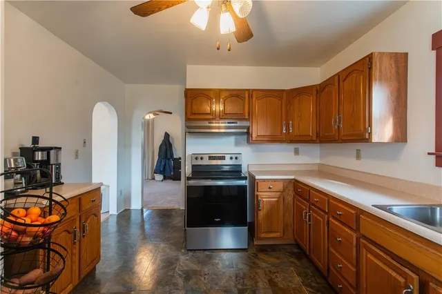 a kitchen with stainless steel appliances granite countertop a stove top oven a sink dishwasher and cabinets with wooden floor