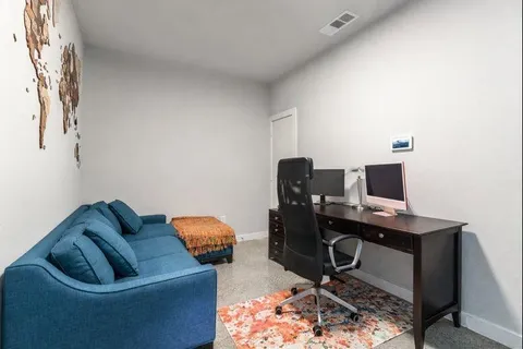 a bedroom with a bed and two large window