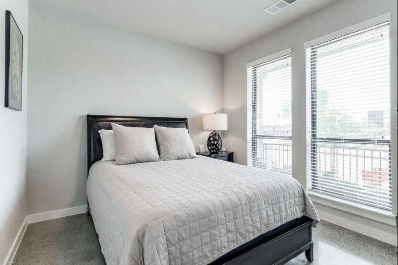 2220 Rook Drive Dallas, TX 75211 - Photo 10 of 12 a bedroom with a bed and two large window