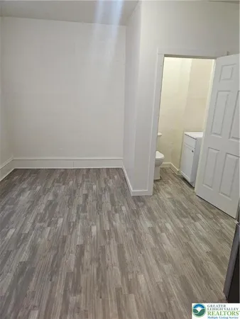 a view of a room with wooden floor and white walls