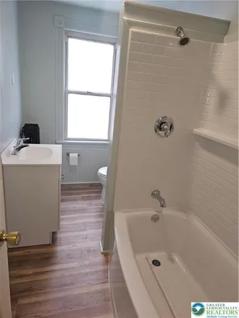 a bathroom with a bathtub and a window