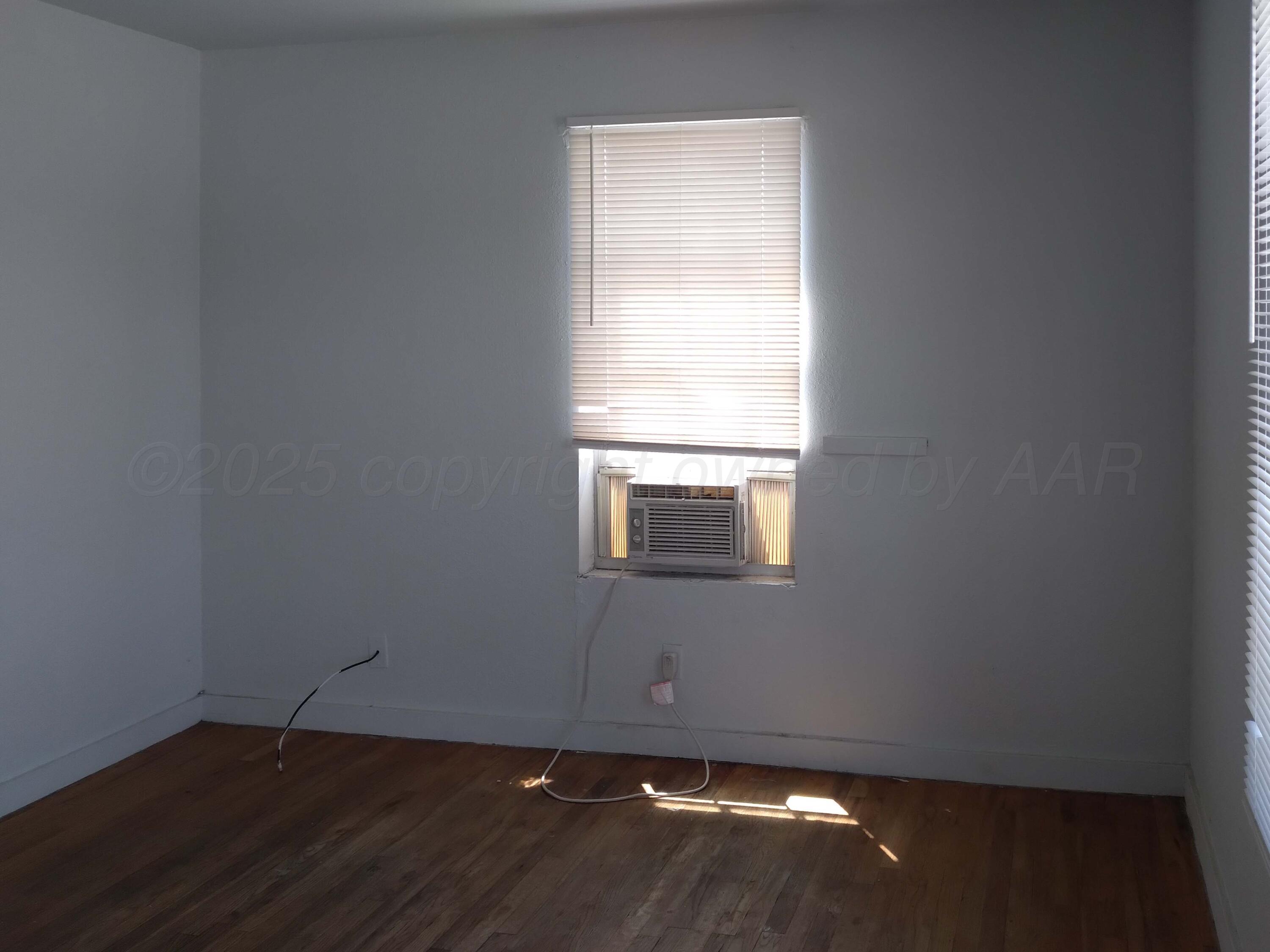 809 South Bryan Street Amarillo, TX 79106 - Photo 13 of 22 a view of an empty room with wooden floor and a window