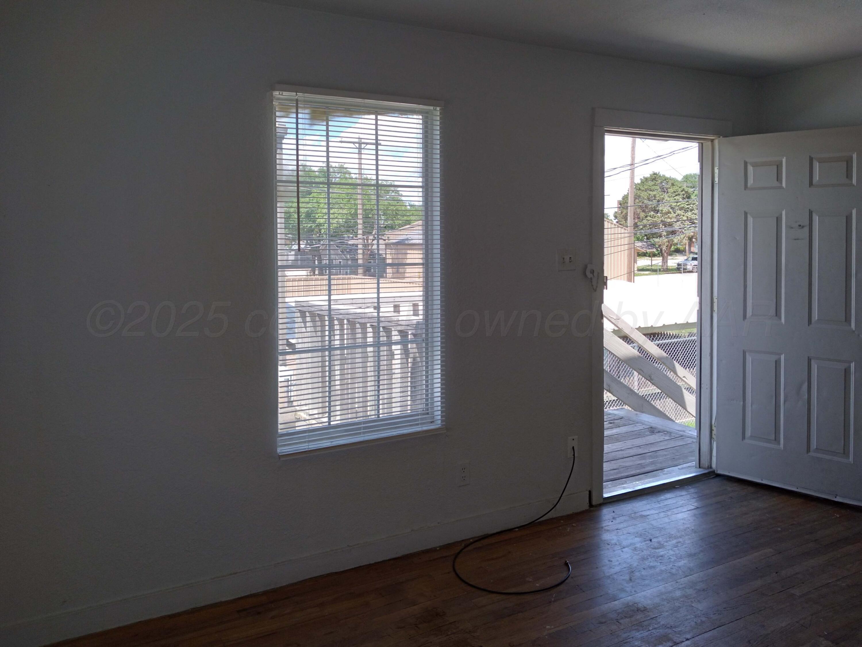 809 South Bryan Street Amarillo, TX 79106 - Photo 14 of 22 a view of an empty room with wooden floor and a window