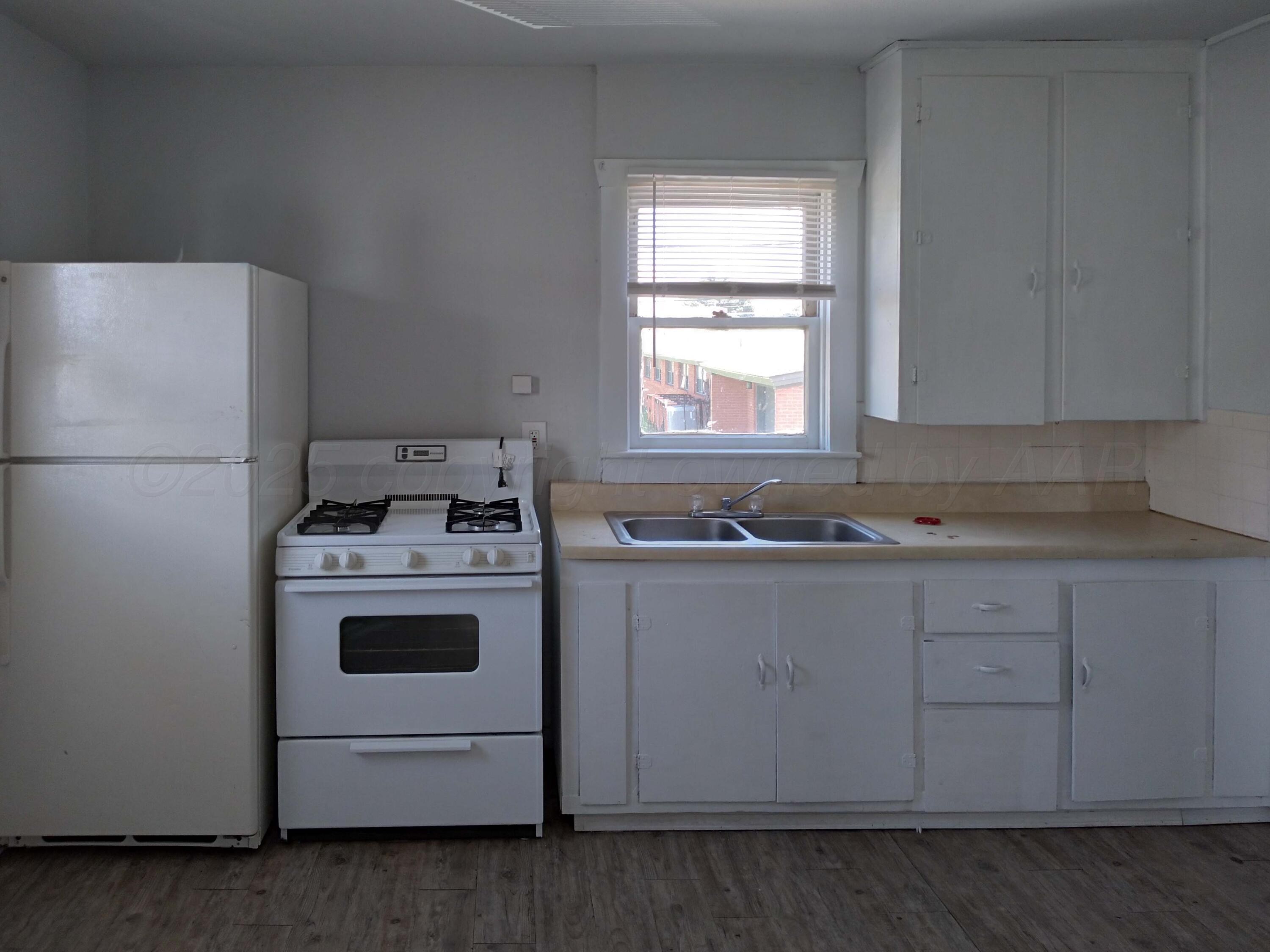 809 South Bryan Street Amarillo, TX 79106 - Photo 16 of 22 a kitchen with a white stove refrigerator and cabinets