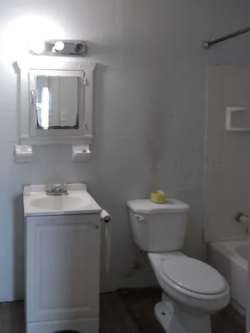 a bathroom with a toilet a sink and mirror