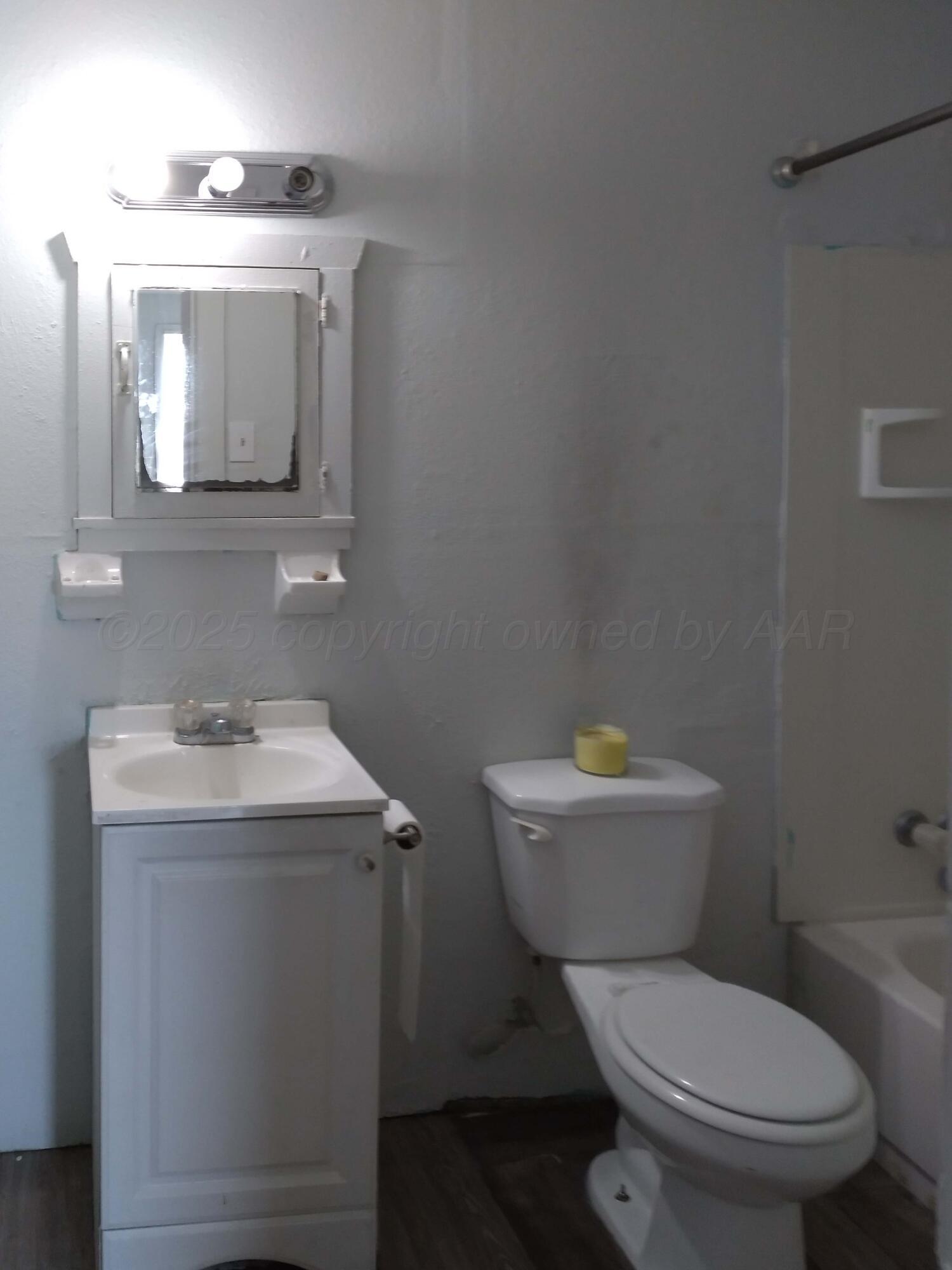 809 South Bryan Street Amarillo, TX 79106 - Photo 18 of 22 a bathroom with a toilet a sink and mirror