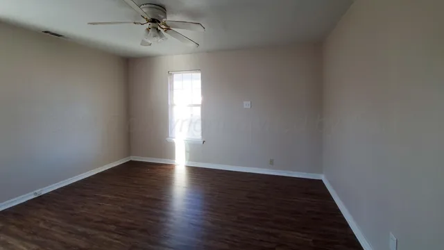 wooden floor in an empty room with a window