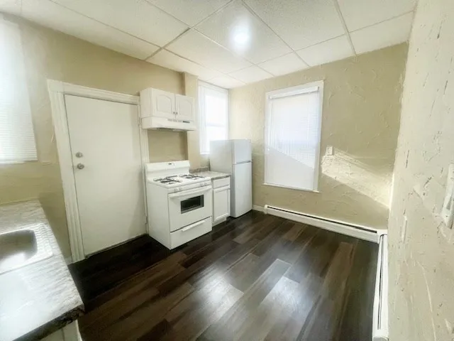 a kitchen with wooden floors and white appliances