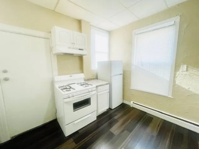 a kitchen with a stove and a wooden floor