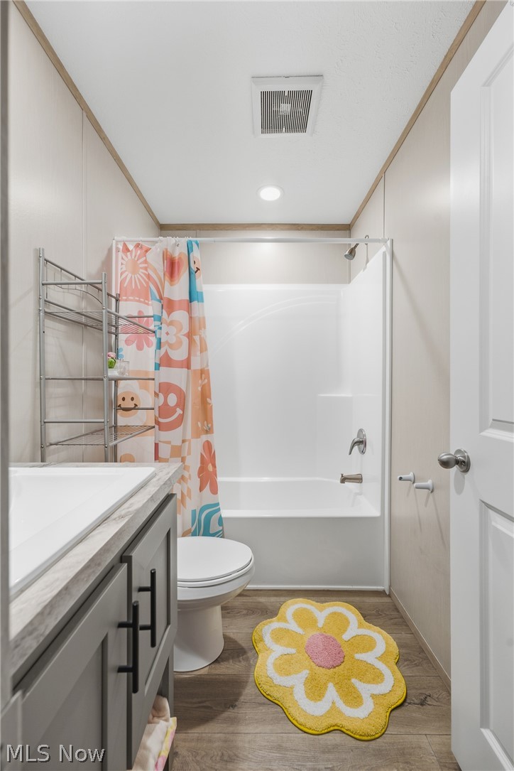 4516 Navarre Road Southwest, Unit 13 Canton, OH 44706 - Photo 20 of 30 Bathroom featuring a built-in shower/tub combination, wood-finish flooring, a white vanity with a gray countertop, and a white toilet