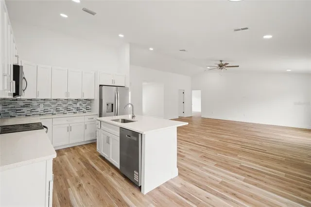 a view of a hallway with wooden floor and a bathroom