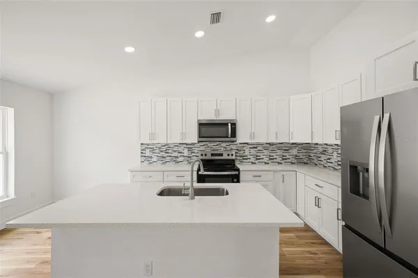 a kitchen with a sink a microwave a stove and refrigerator