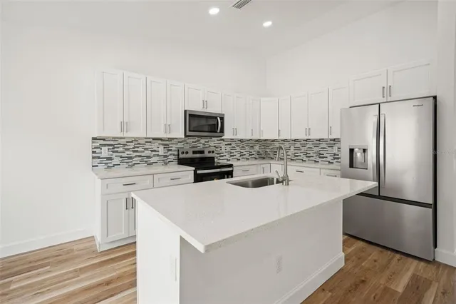 a kitchen with appliances a sink and a refrigerator