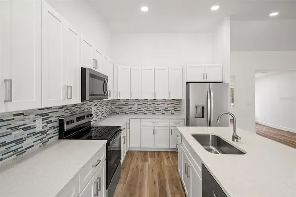 a kitchen with a stove a sink and a refrigerator