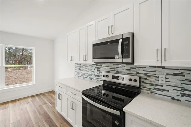 a kitchen with granite countertop a stove and a microwave