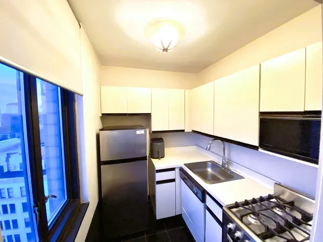 a kitchen with stainless steel appliances granite countertop a refrigerator and a stove
