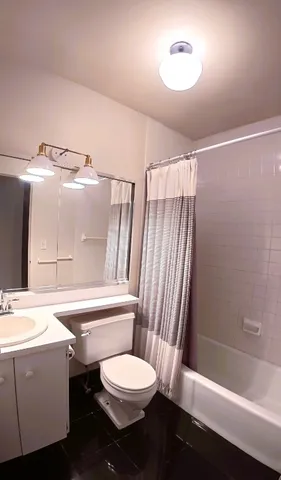 a bathroom with a sink a toilet a mirror and shower