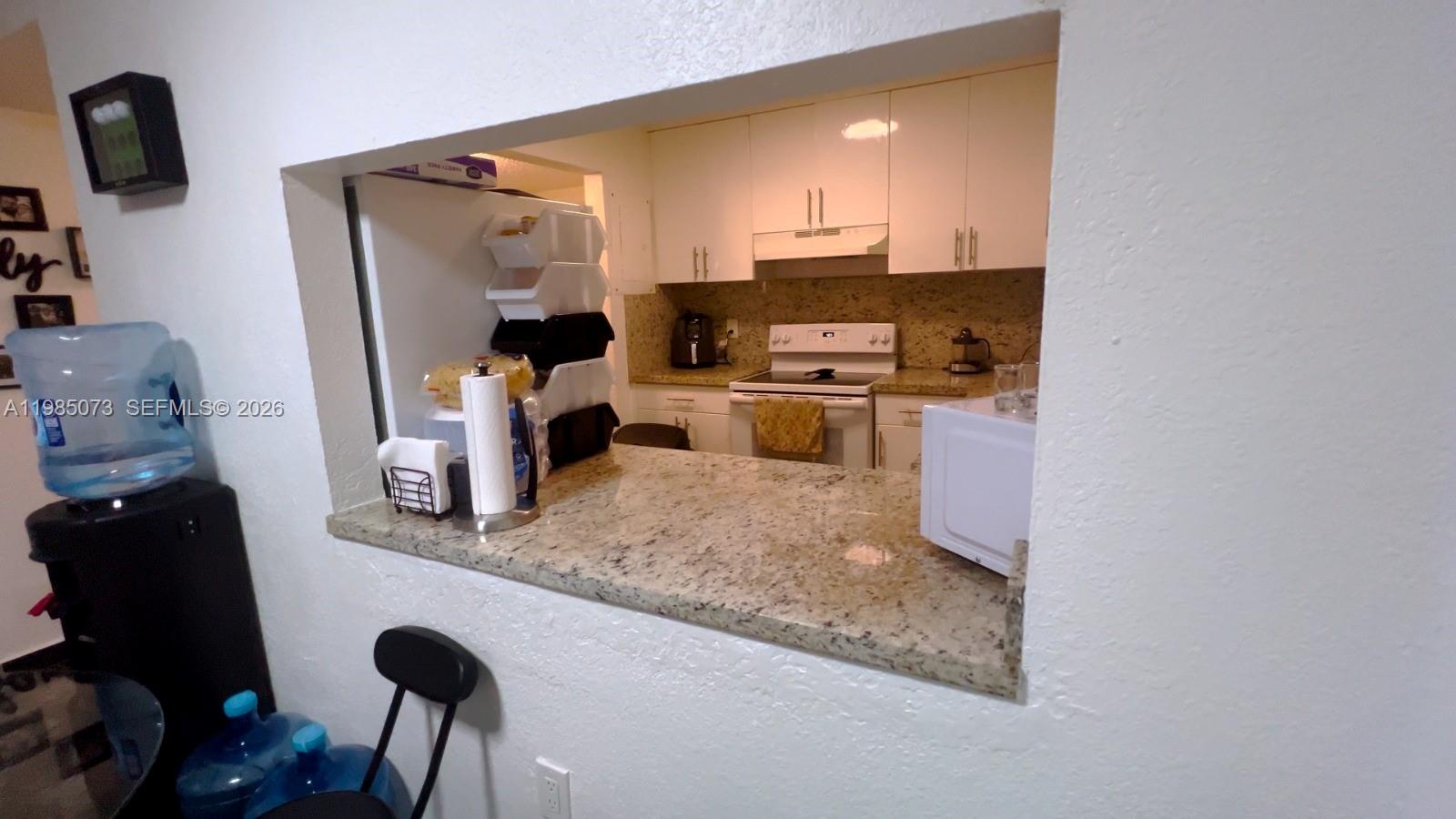 1900 West 68th Street, Unit D207 Hialeah, FL 33014 - Photo 2 of 33 a kitchen with stainless steel appliances granite countertop a sink stove and refrigerator