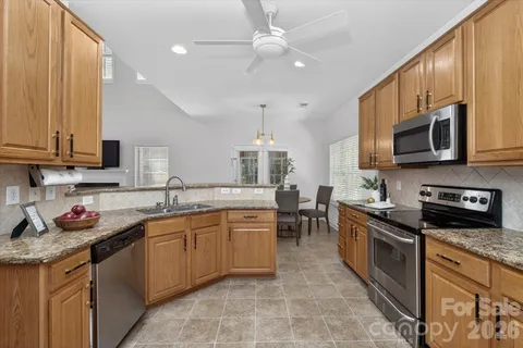 a kitchen with stainless steel appliances granite countertop a sink stove microwave and cabinets