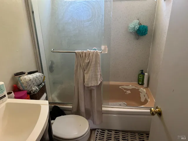 a bathroom with a toilet and a shower
