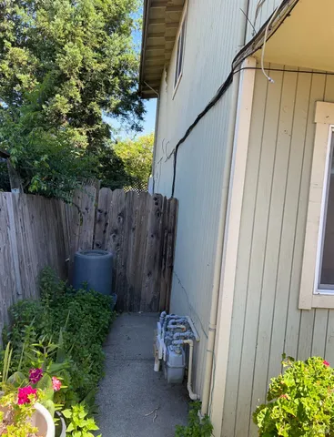 a backyard with potted plants and a chair