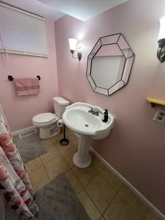 a bathroom with a sink toilet and mirror