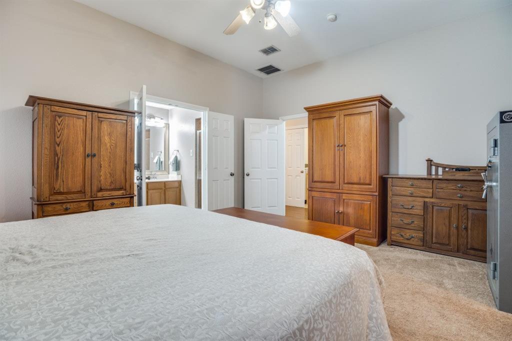 108 High Meadows Court Decatur, TX 76234 - Photo 11 of 29 a bedroom with a bed and dresser with mirror
