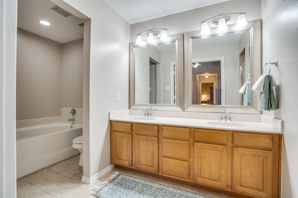 108 High Meadows Court Decatur, TX 76234 - Photo 14 of 29 a bathroom with a double vanity sink a mirror and a bathtub