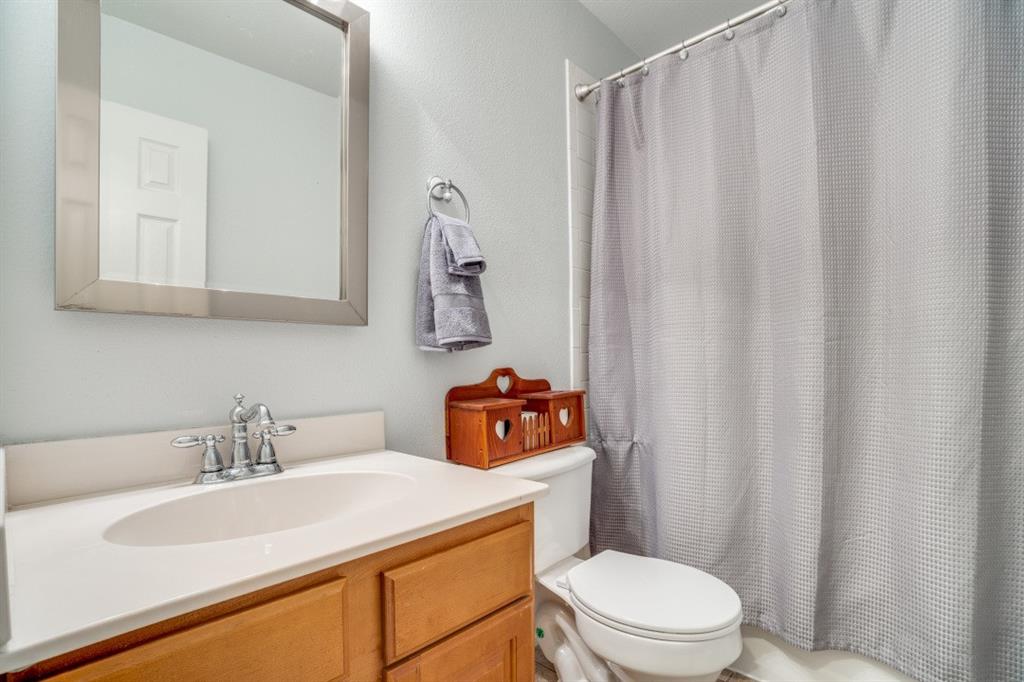 108 High Meadows Court Decatur, TX 76234 - Photo 16 of 29 a bathroom with a sink a toilet and shower curtain