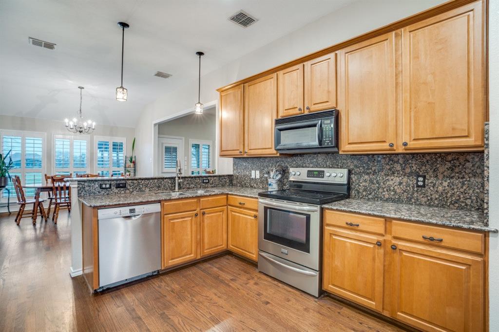 108 High Meadows Court Decatur, TX 76234 - Photo 7 of 29 a kitchen with stainless steel appliances granite countertop wooden floors and granite counter tops