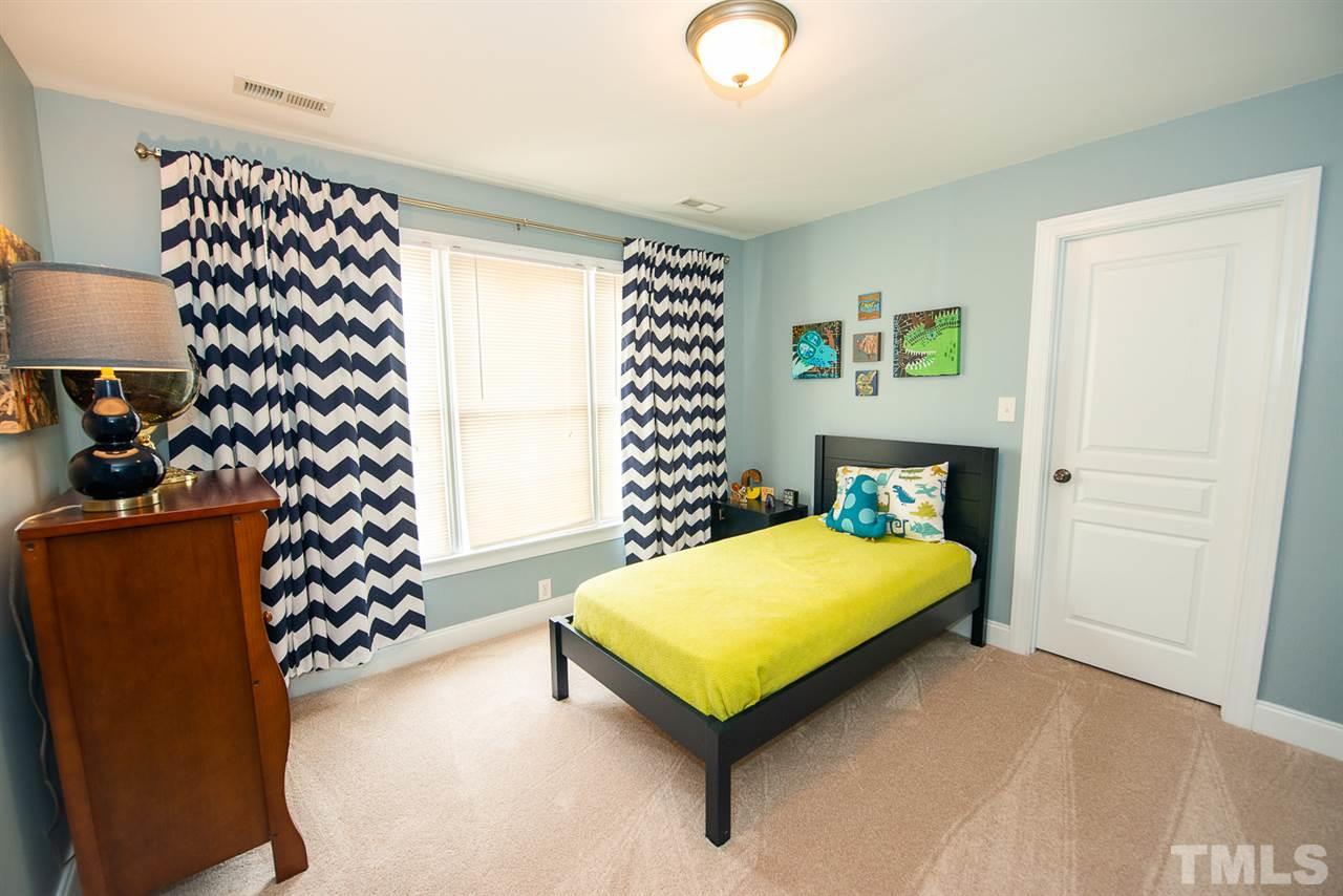 81 Rand Road Raleigh, NC 27603 - Photo 14 of 24 a bed room with a bed and a chair