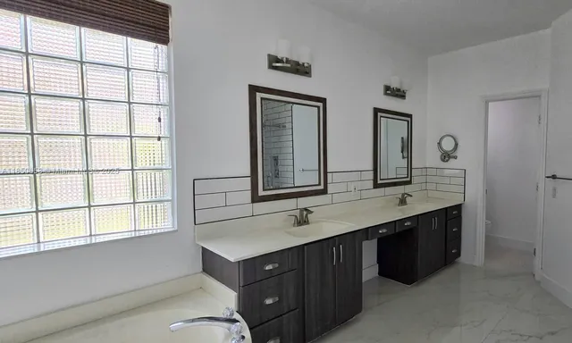 a bathroom with a double vanity sink and a window