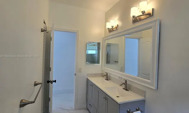a bathroom with a double vanity sink a mirror and a shower