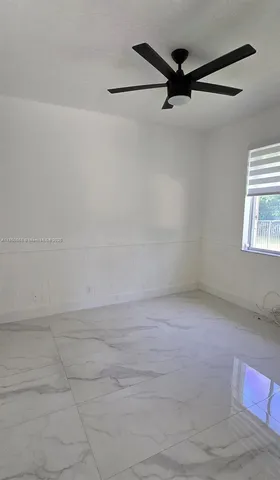 a view of a livingroom with a ceiling fan and window