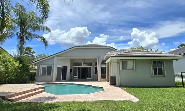 a front view of a house with a yard and potted plants