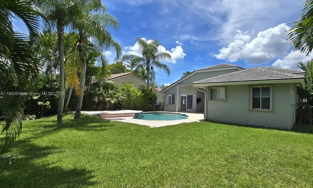 a view of a house with a backyard and a tree