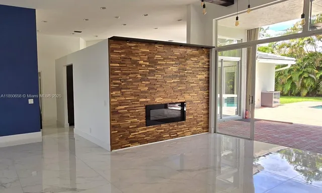 a view of an empty room with a fireplace and a window