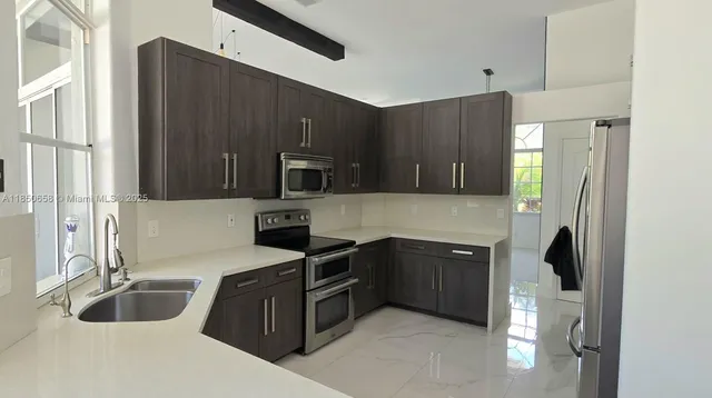 a kitchen with stainless steel appliances granite countertop a sink stove and refrigerator