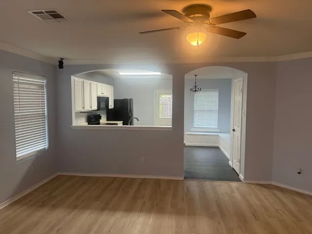 a view of a kitchen with wooden floor and a ceiling fan
