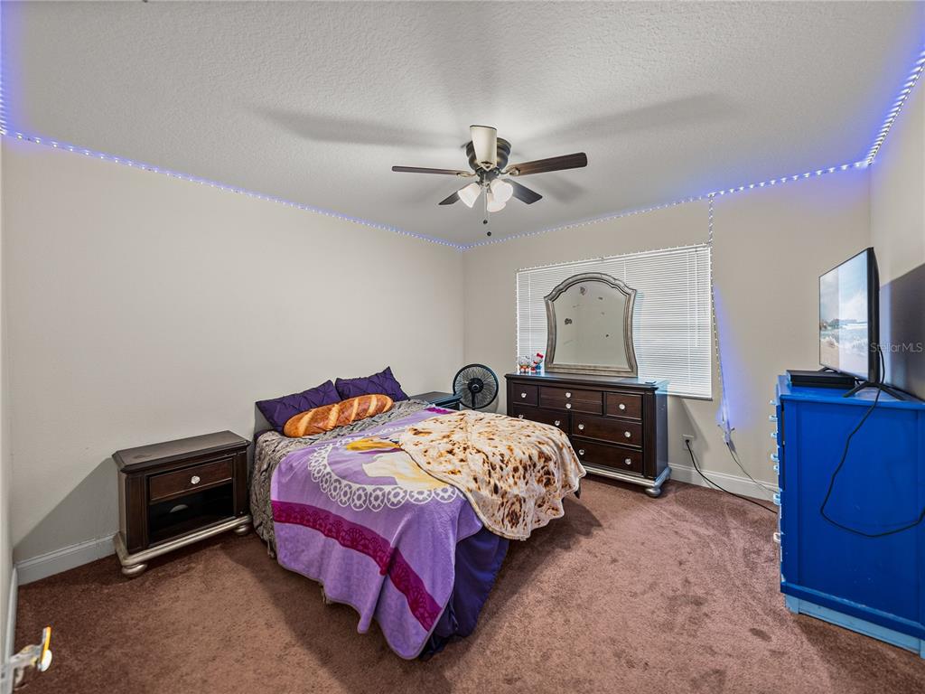 609 West Pipkin Road Lakeland, FL 33813 - Photo 30 of 72 a bedroom with a bed dresser and a flat tv screen