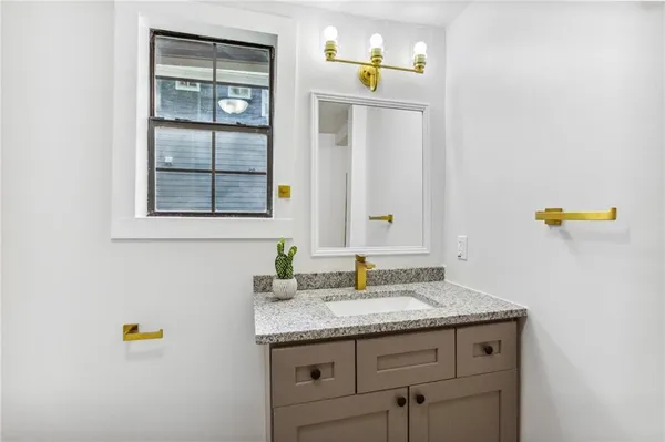 a bathroom with a granite countertop sink and a mirror