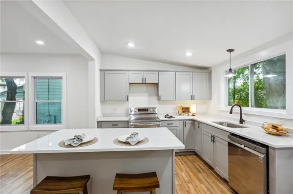 a kitchen with a sink a stove and cabinets