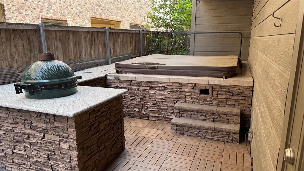 4516 Gilbert Avenue Dallas, TX 75219 - Photo 26 of 28 Patio area featuring a built-in hot tub with stone-clad surround and steps