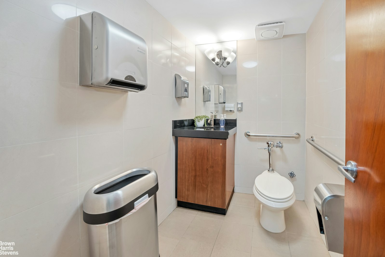 235 East 22nd Street, Unit 1EF Manhattan, NY 10010 - Photo 10 of 15 a bathroom with a toilet a sink and mirror