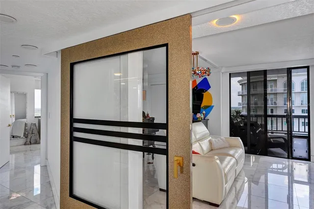 a living room with furniture a flat screen tv and a floor to ceiling window