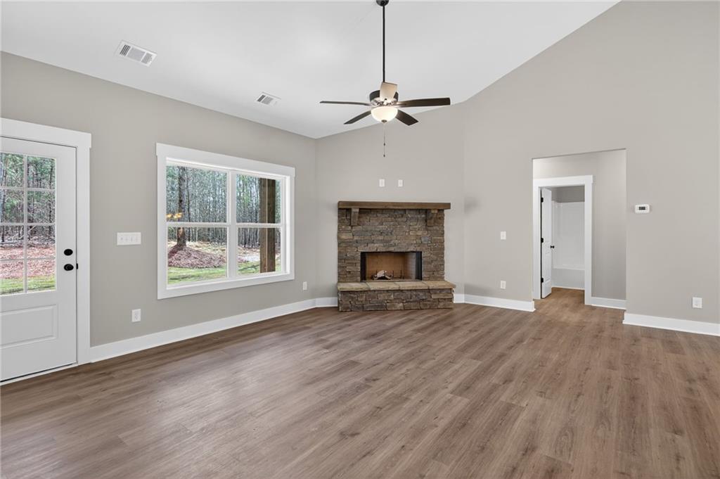 423 Relay Road Silver Creek, GA 30173 - Photo 15 of 48 an empty room with wooden floor fireplace and windows